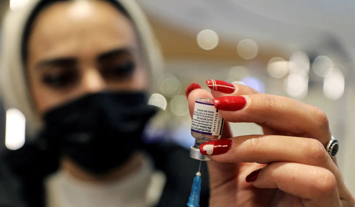 A health worker prepares a dose